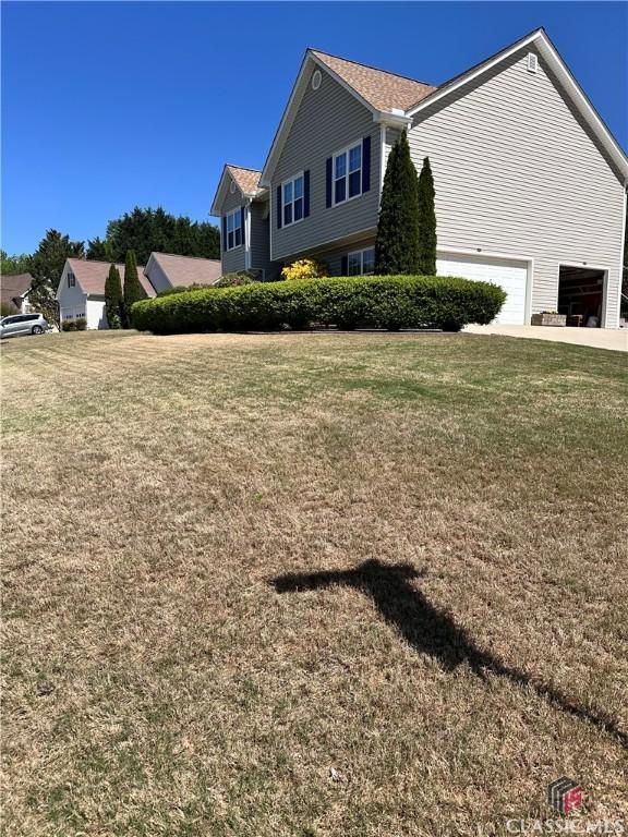 view of side of property featuring a garage and a yard
