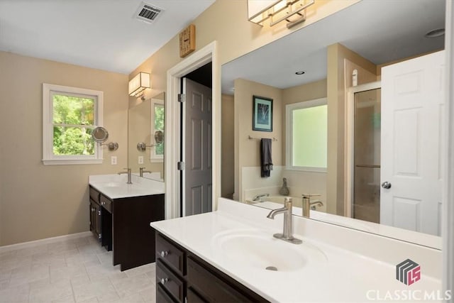 1130 Latham Dr, Watkinsville, GA 30677 - bathroom with two vanities, baseboards, a bath, tile patterned floors, and a stall shower