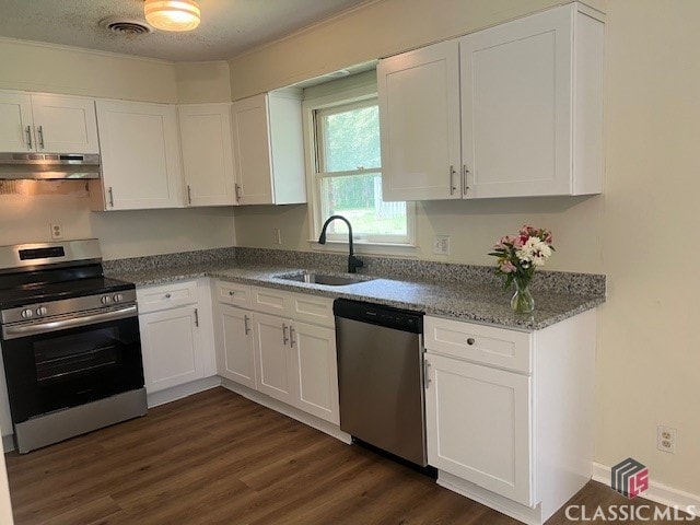 kitchen with white cabinets, a sink, stainless steel appliances, under cabinet range hood, and dark wood-style floors