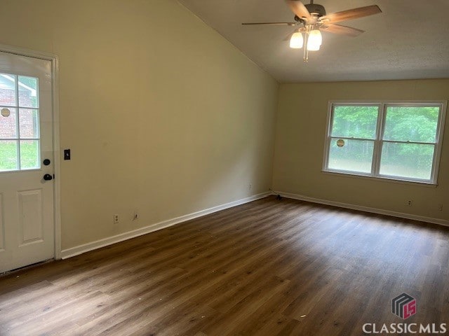 empty room with dark wood-type flooring, ceiling fan, and lofted ceiling