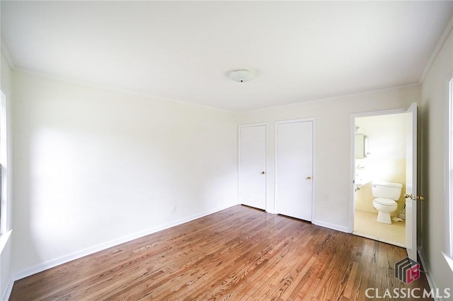 120 Hunt Rd, Athens, GA 30606 - unfurnished bedroom with baseboards, ornamental molding, ensuite bathroom, and wood finished floors