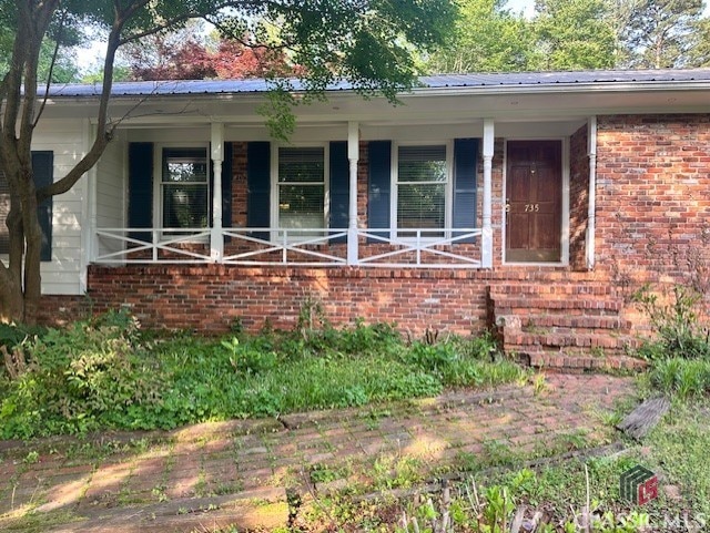 735 Timothy Rd, Athens, GA 30606 - view of exterior entry featuring metal roof, brick siding, and covered porch