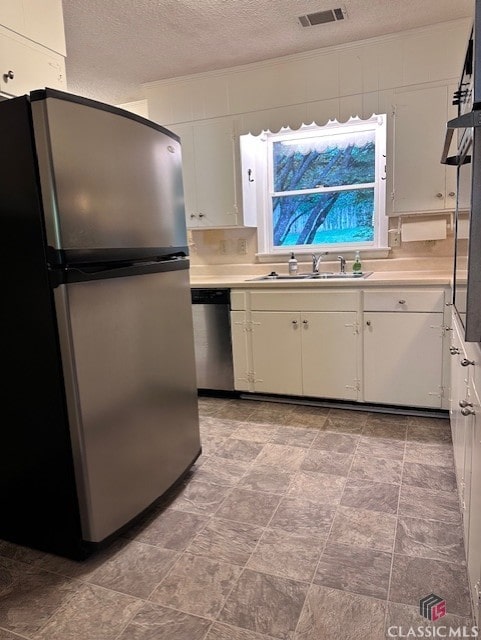 735 Timothy Rd, Athens, GA 30606 - kitchen with a textured ceiling, visible vents, a sink, stainless steel appliances, and white cabinets