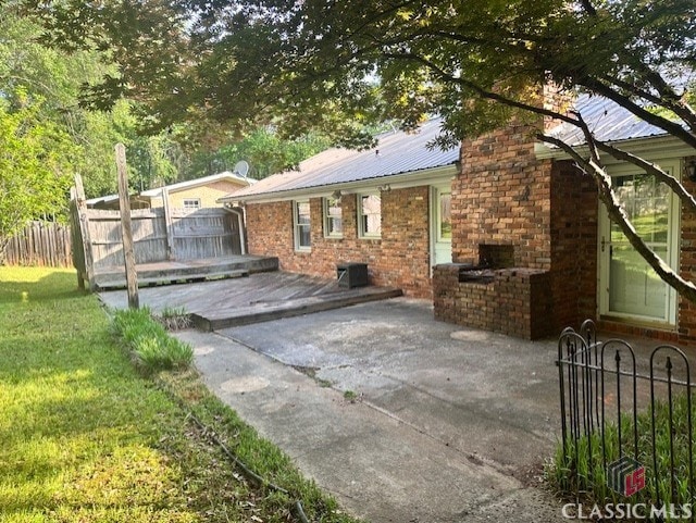 735 Timothy Rd, Athens, GA 30606 - exterior space featuring fence, a patio area, brick siding, a fireplace, and metal roof
