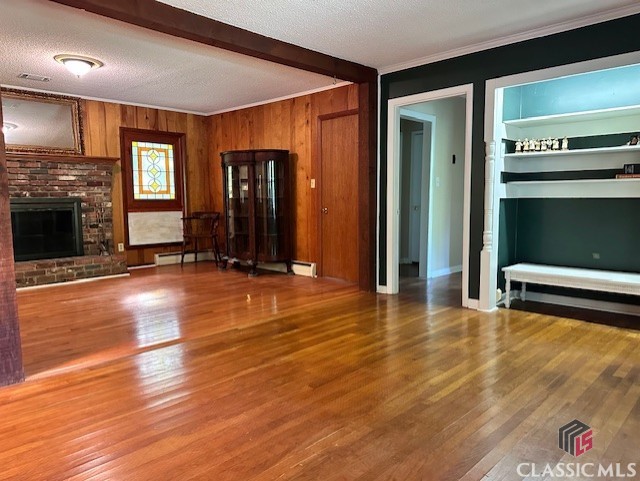 735 Timothy Rd, Athens, GA 30606 - unfurnished living room with a fireplace, ornamental molding, wood finished floors, and beam ceiling