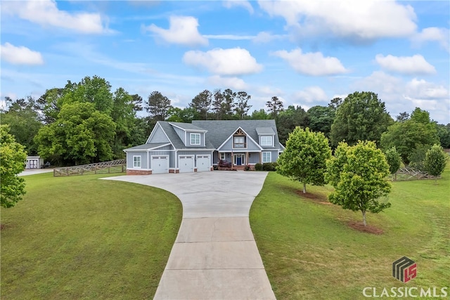view of front of house with a front lawn, driveway, fence, and a garage