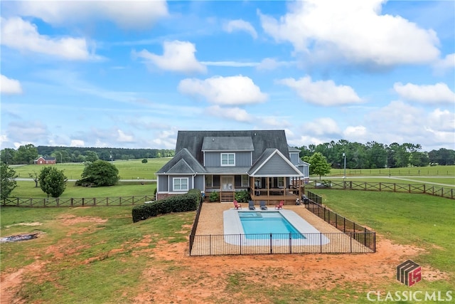 rear view of property featuring a yard, a fenced in pool, a fenced backyard, and a patio area