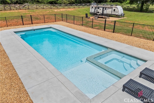 view of pool featuring a pool with connected hot tub, a lawn, and a fenced backyard