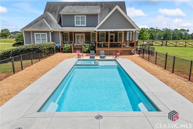 back of house featuring a lawn, a shingled roof, a fenced in pool, and board and batten siding