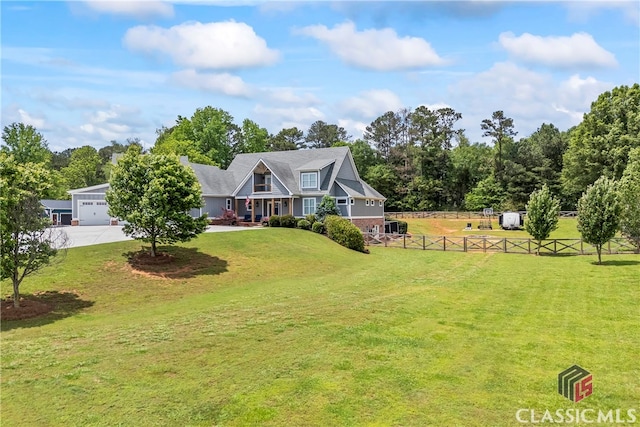 view of front facade with fence, a front lawn, and driveway