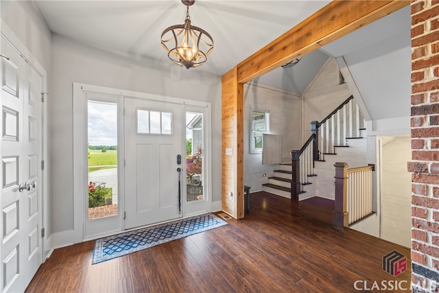 foyer featuring stairway, a chandelier, baseboards, and wood finished floors