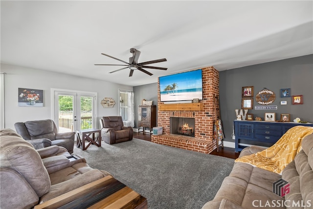 living room featuring wood finished floors, a ceiling fan, and a brick fireplace