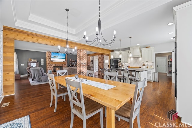 dining room featuring a notable chandelier, dark wood finished floors, a fireplace, and recessed lighting