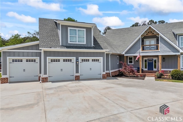craftsman house featuring concrete driveway, board and batten siding, a porch, and roof with shingles