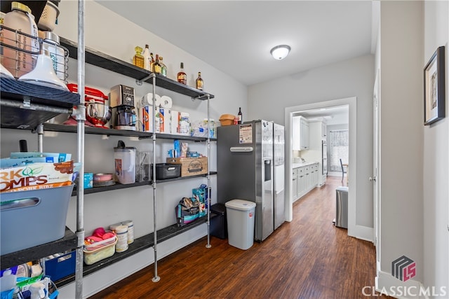 interior space featuring stainless steel fridge with ice dispenser, white cabinets, and dark wood finished floors