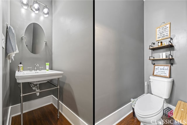 bathroom with toilet, wood finished floors, and baseboards