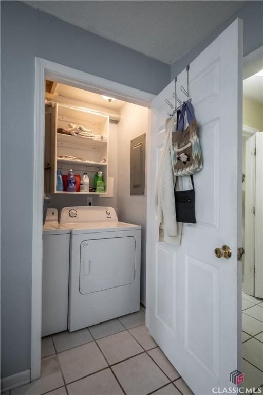 laundry room with electric panel, laundry area, light tile patterned floors, and washer and dryer