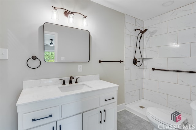 bathroom with vanity, toilet, and a tile shower