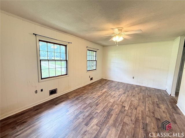 empty room featuring dark wood-style floors, a textured ceiling, ceiling fan, and baseboards