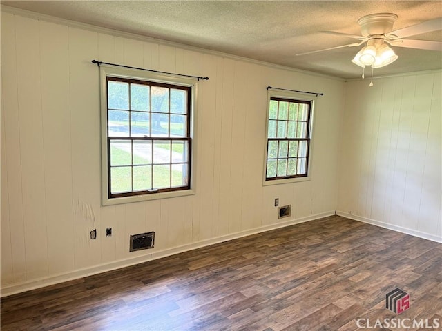spare room with dark wood finished floors, ceiling fan, a textured ceiling, ornamental molding, and baseboards
