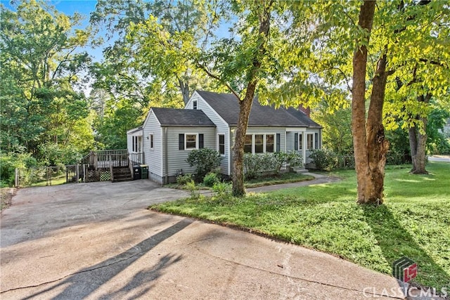 120 Mathews Ave, Athens, GA 30606 - view of front of house featuring concrete driveway, a deck, a chimney, and view of scattered trees