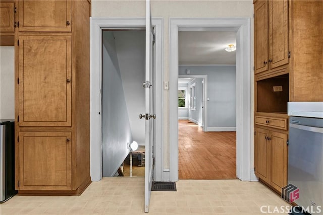 120 Mathews Ave, Athens, GA 30606 - kitchen featuring stainless steel dishwasher, brown cabinets, baseboards, and ornamental molding