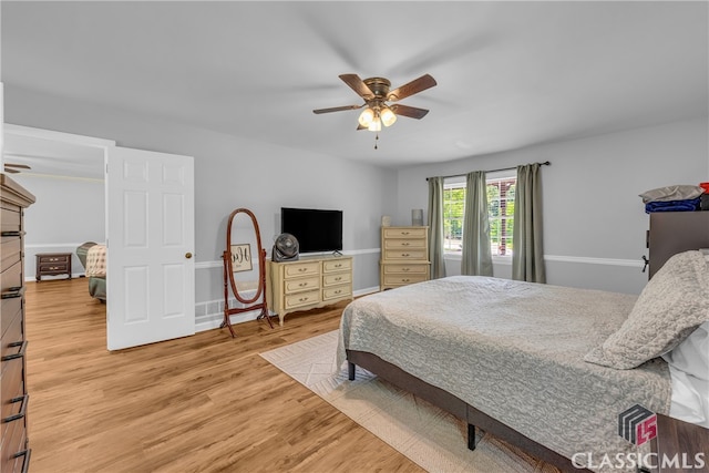 bedroom featuring light wood-type flooring, a ceiling fan, and baseboards