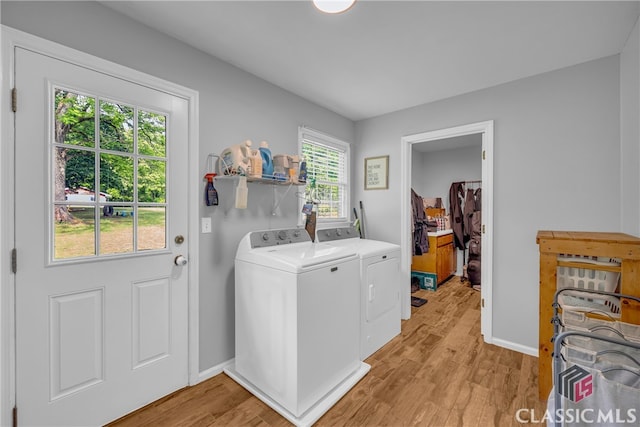 washroom with separate washer and dryer, light wood finished floors, and baseboards