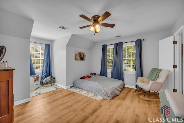 bedroom with light wood-style flooring, multiple windows, and baseboards