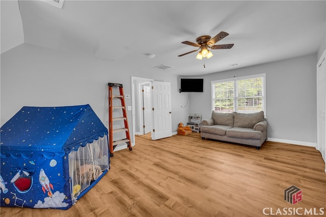 living area featuring a ceiling fan, wood finished floors, and baseboards