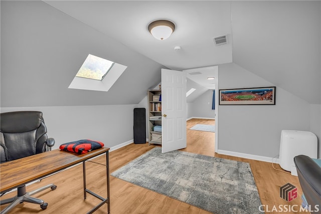 office space featuring a skylight, baseboards, vaulted ceiling, and wood finished floors