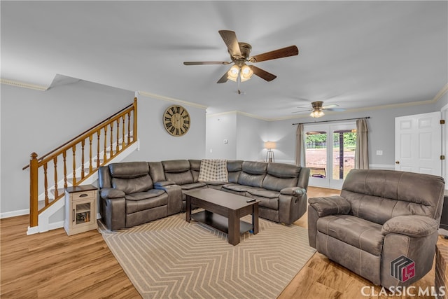 living room featuring a ceiling fan, crown molding, stairs, light wood-type flooring, and baseboards