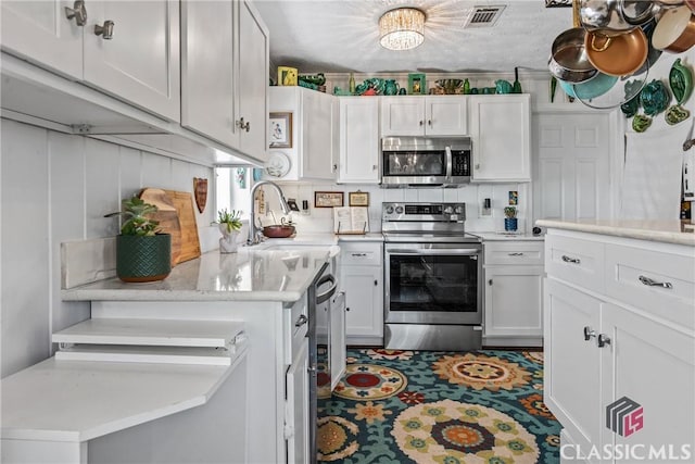 3081 Macedonia Rd, Union Point, GA 30669 - kitchen featuring appliances with stainless steel finishes, light countertops, white cabinetry, and a sink