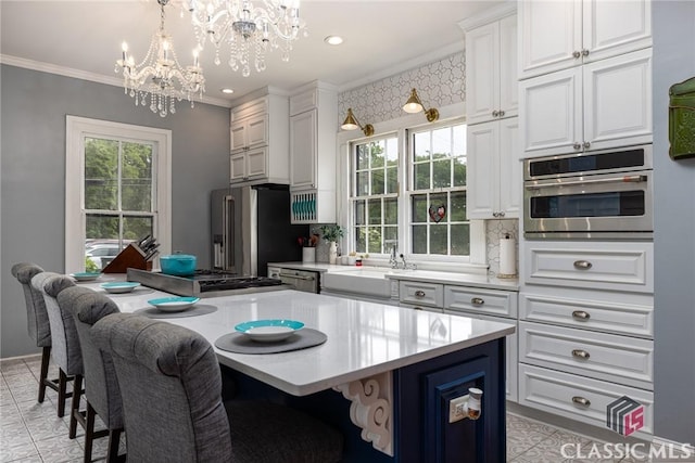 172 N Second St, Madison, GA 30650 - kitchen with a chandelier, stainless steel appliances, a sink, a center island, and light countertops