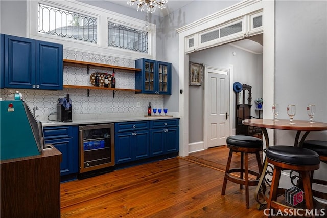 172 N Second St, Madison, GA 30650 - indoor dry bar with wine cooler, dark wood-style flooring, backsplash, and a chandelier