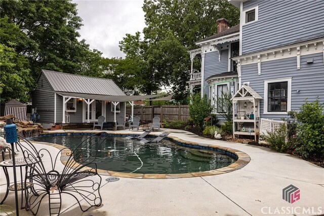 172 N Second St, Madison, GA 30650 - view of swimming pool with fence, a patio, an outdoor structure, and a storage structure