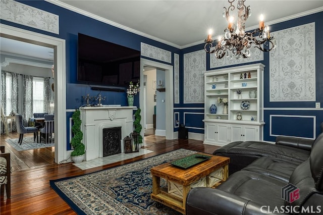 172 N Second St, Madison, GA 30650 - living room featuring a chandelier, wood-type flooring, ornamental molding, wallpapered walls, and a fireplace with flush hearth