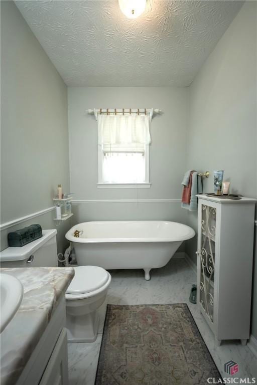 1181 Pete Dickens Rd, Bogart, GA 30622 - bathroom featuring toilet, a freestanding bath, marble finish flooring, vanity, and a textured ceiling