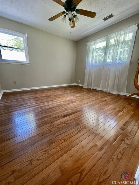 1181 Pete Dickens Rd, Bogart, GA 30622 - unfurnished bedroom featuring wood finished floors, baseboards, and a textured ceiling