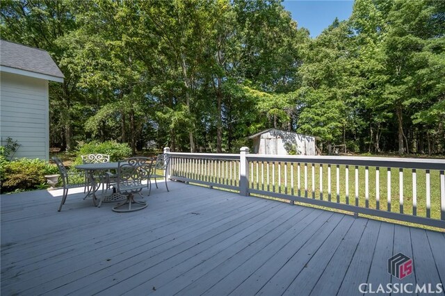 1181 Pete Dickens Rd, Bogart, GA 30622 - deck with ceiling fan, outdoor dining area, and covered porch