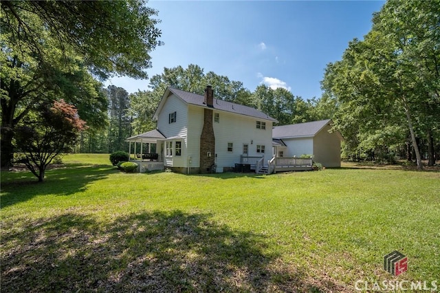 1181 Pete Dickens Rd, Bogart, GA 30622 - rear view of house with a chimney, a wooden deck, a lawn, a sunroom, and view of scattered trees