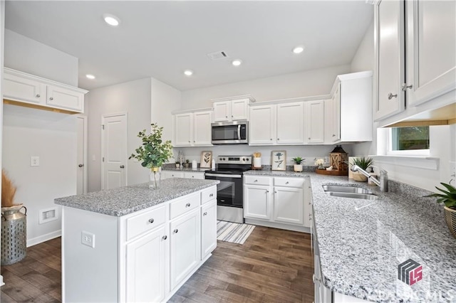 132 Water Oak Way, Crawford, GA 30630 - kitchen featuring appliances with stainless steel finishes, a sink, white cabinetry, dark wood-style flooring, and a center island