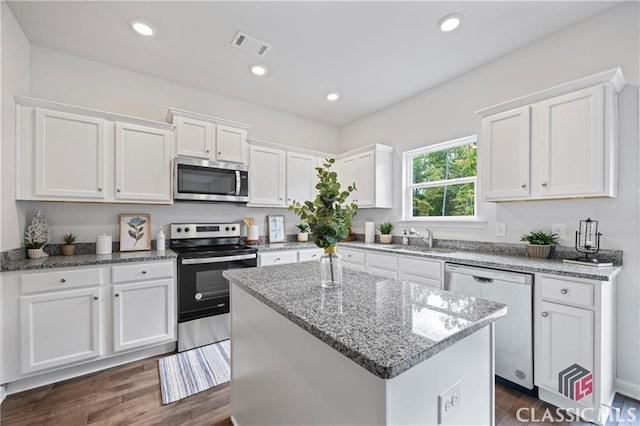 132 Water Oak Way, Crawford, GA 30630 - kitchen with appliances with stainless steel finishes, a sink, white cabinets, a kitchen island, and recessed lighting