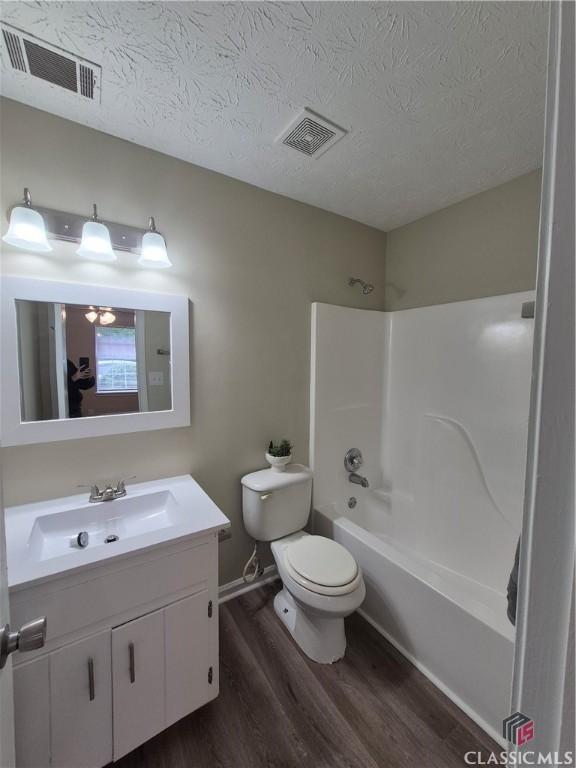 115 Big Oak Cir, Athens, GA 30605 - bathroom with wood finished floors, vanity, toilet, shower / bathtub combination, and a textured ceiling