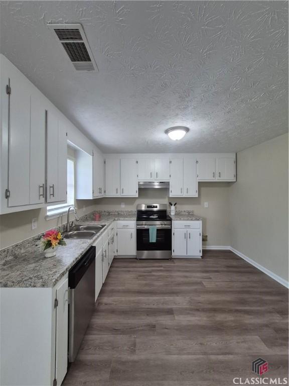 115 Big Oak Cir, Athens, GA 30605 - kitchen with stainless steel appliances, a sink, under cabinet range hood, white cabinets, and a textured ceiling