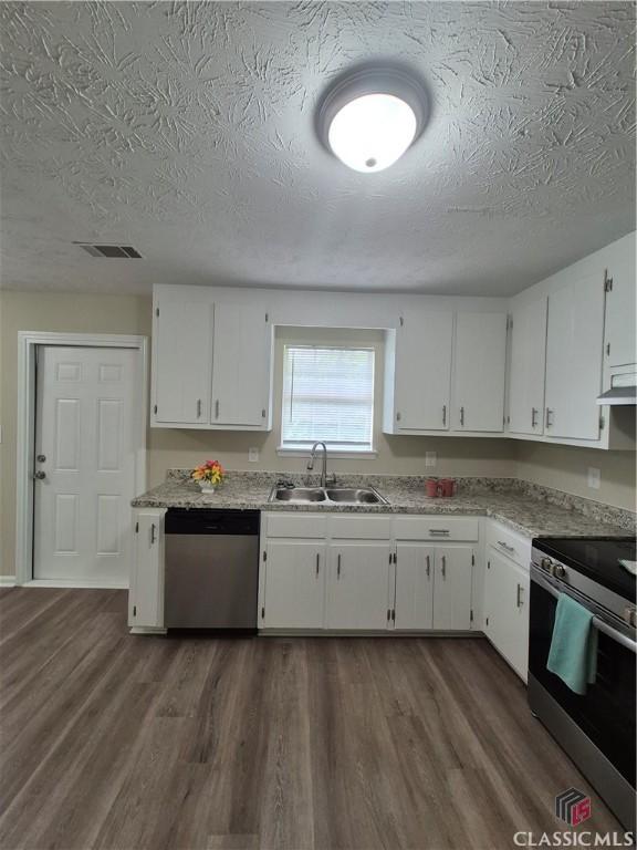 115 Big Oak Cir, Athens, GA 30605 - kitchen with appliances with stainless steel finishes, a sink, a textured ceiling, white cabinets, and dark wood-style floors