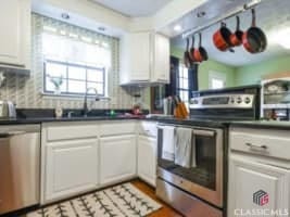 256 Cherokee Rdg, Athens, GA 30606 - kitchen with stainless steel appliances, white cabinetry, dark countertops, and backsplash