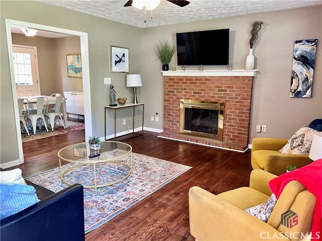 256 Cherokee Rdg, Athens, GA 30606 - living room featuring ceiling fan, a textured ceiling, a fireplace, wood finished floors, and baseboards