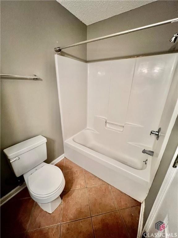 bathroom with tile patterned flooring, toilet, a textured ceiling, shower / bath combination, and baseboards