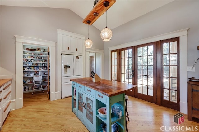 kitchen with wooden counters, white fridge with ice dispenser, french doors, white cabinetry, and light wood-type flooring